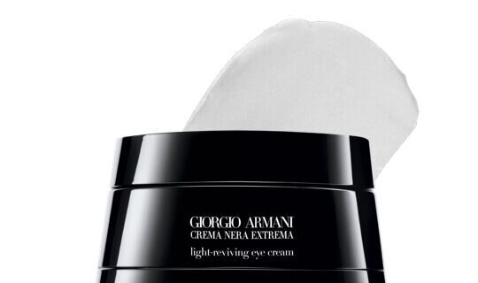 Een potje Giorgio Armani Crema Nera Extrema oogcreme met een lepelvormige hoeveelheid creme erbovenop.