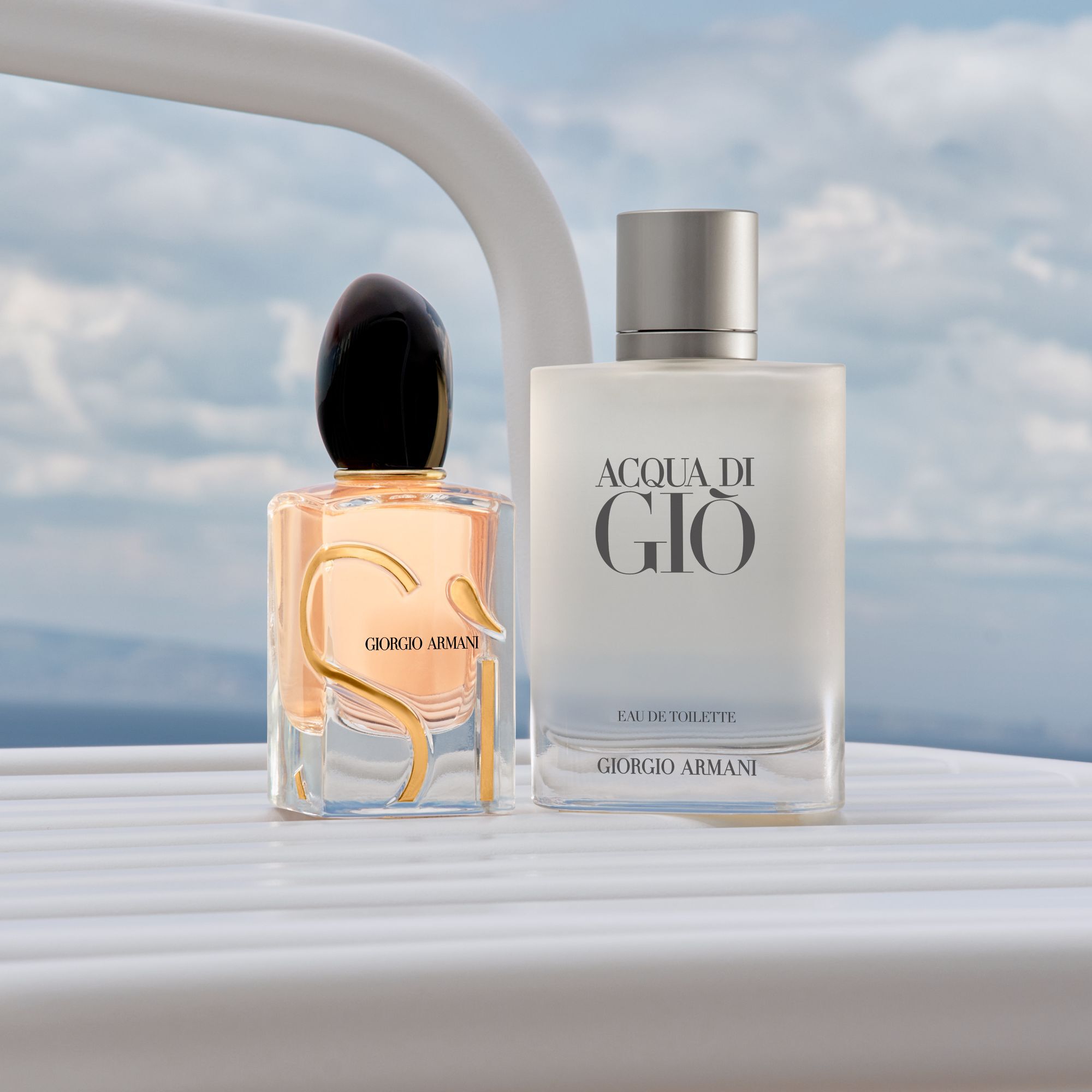 Un duo sophistique d'icones Armani : l'eclatant Si et le frais Acqua di Gio. Poses sur le bastingage d'un yacht blanc face a une mer sereine, ils incarnent une elegance intemporelle et l'esprit d'une escapade cotiere luxueuse.