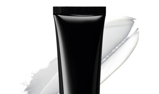 Zwarte tube met een witte creme ernaast.