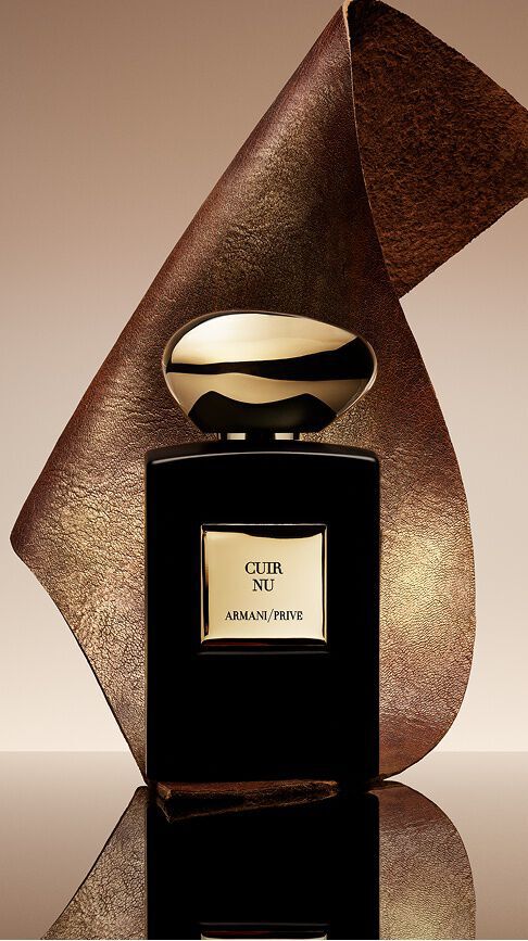 Armani/Prive Cuir Nu: an elegant black bottle with a gold cap, draped in a textured leather ribbon, embodying the sensuality of bare skin and the ultimate refinement of an exceptional woody, leathery trail.