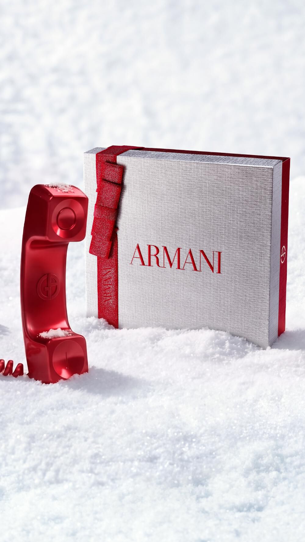 Armani Beauty-kerstgeschenkdoos met een rode telefoon die de klantenservice symboliseert, in een besneeuwd decor.