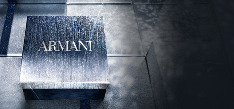 An arrangement of luxury fragrance bottles and gift boxes against a vibrant red background, showcasing elegant packaging design.