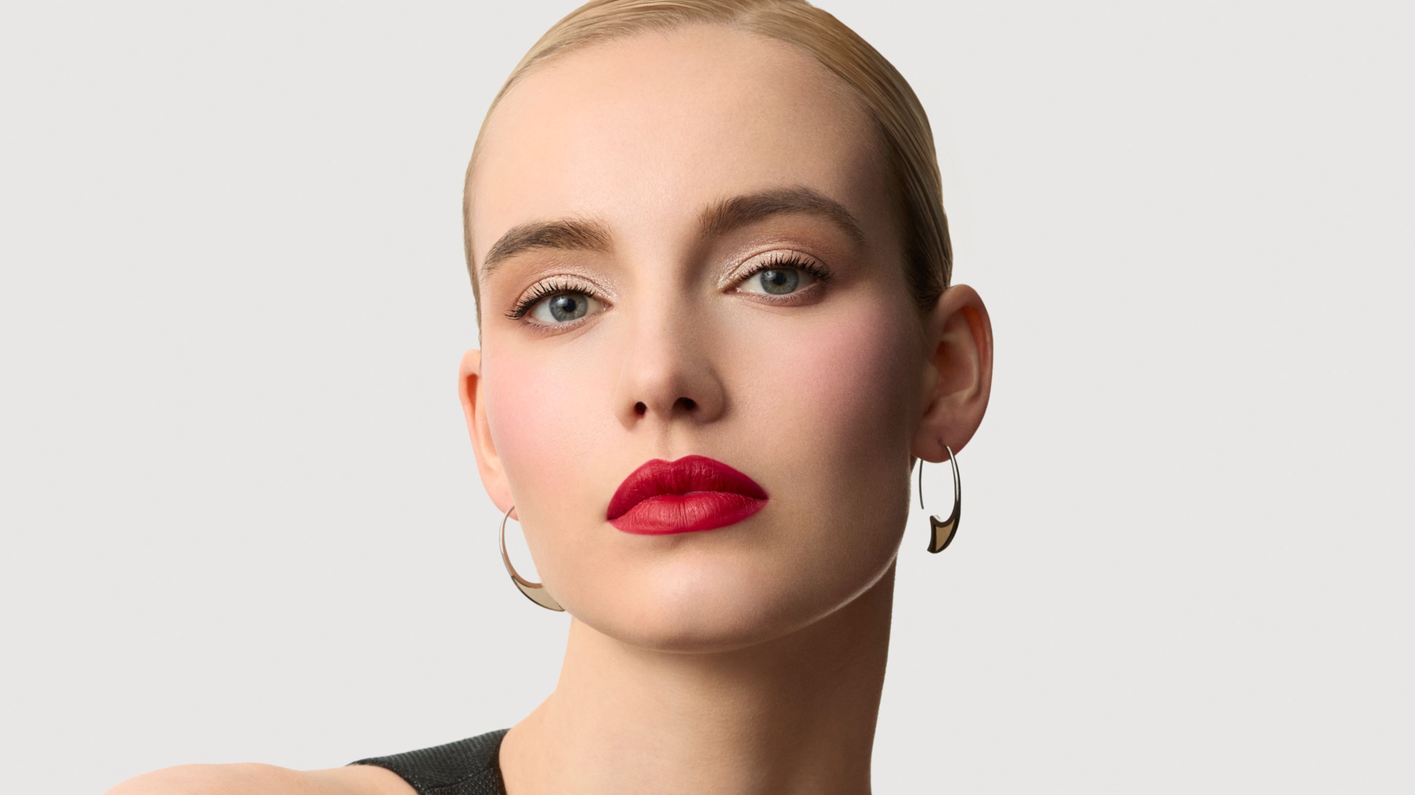 Gros plan d'une femme blonde au maquillage elegant et rouge a levres rouge vif.