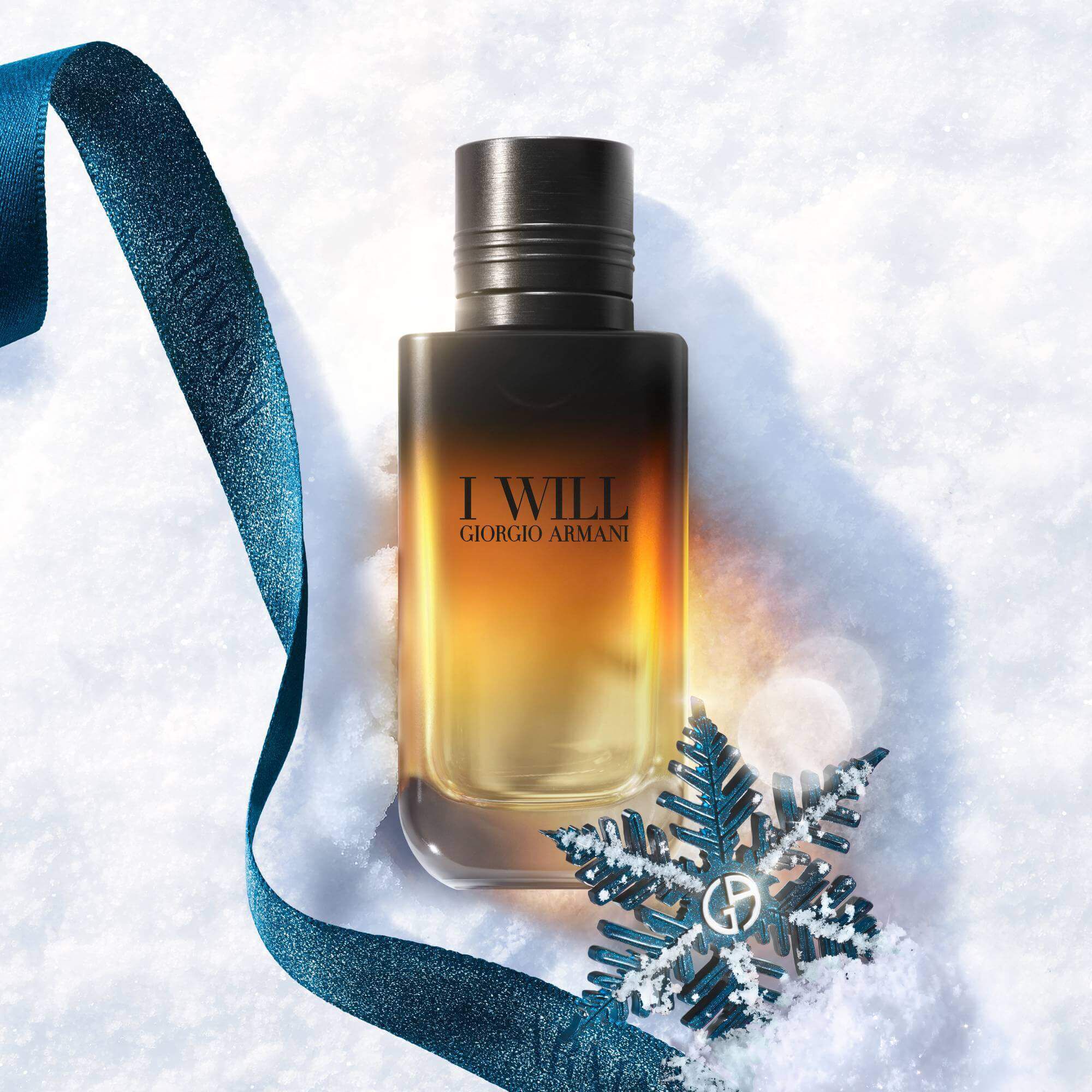 Zwarte en amber Armani cadeaudoos met turquoise lint op een besneeuwd oppervlak — I Will Eau de Parfum herengeur-cadeauset, feestcadeau-visual.