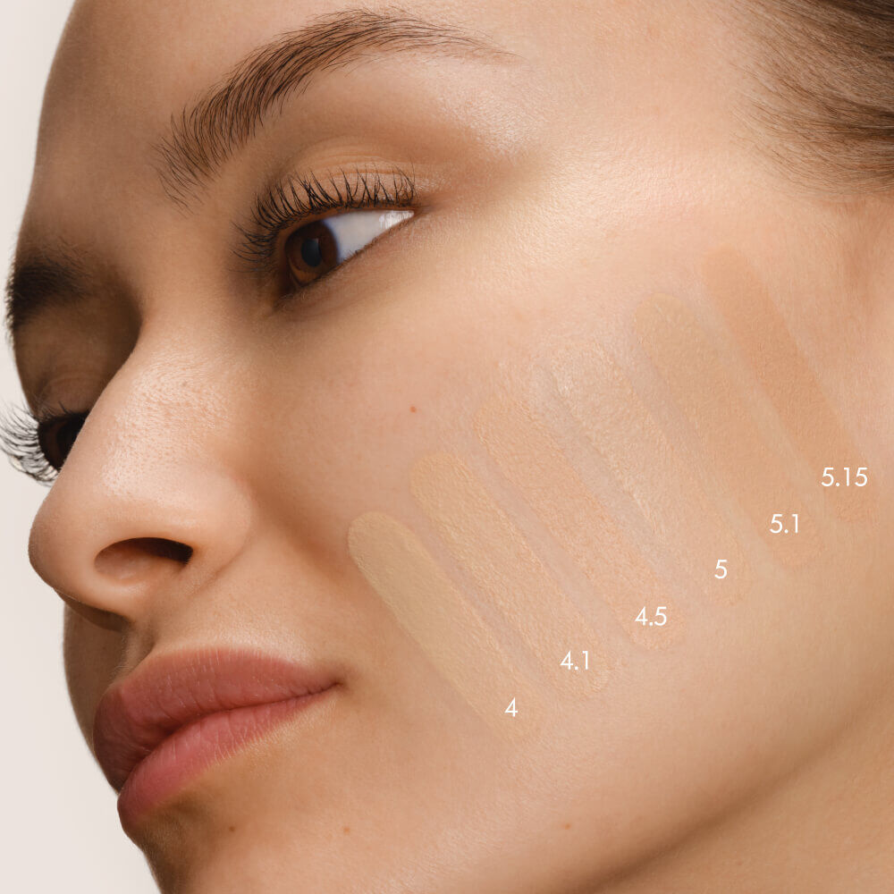 Close-up of a model's cheek with five swatches of LUMINOUS SILK FOUNDATION in shades