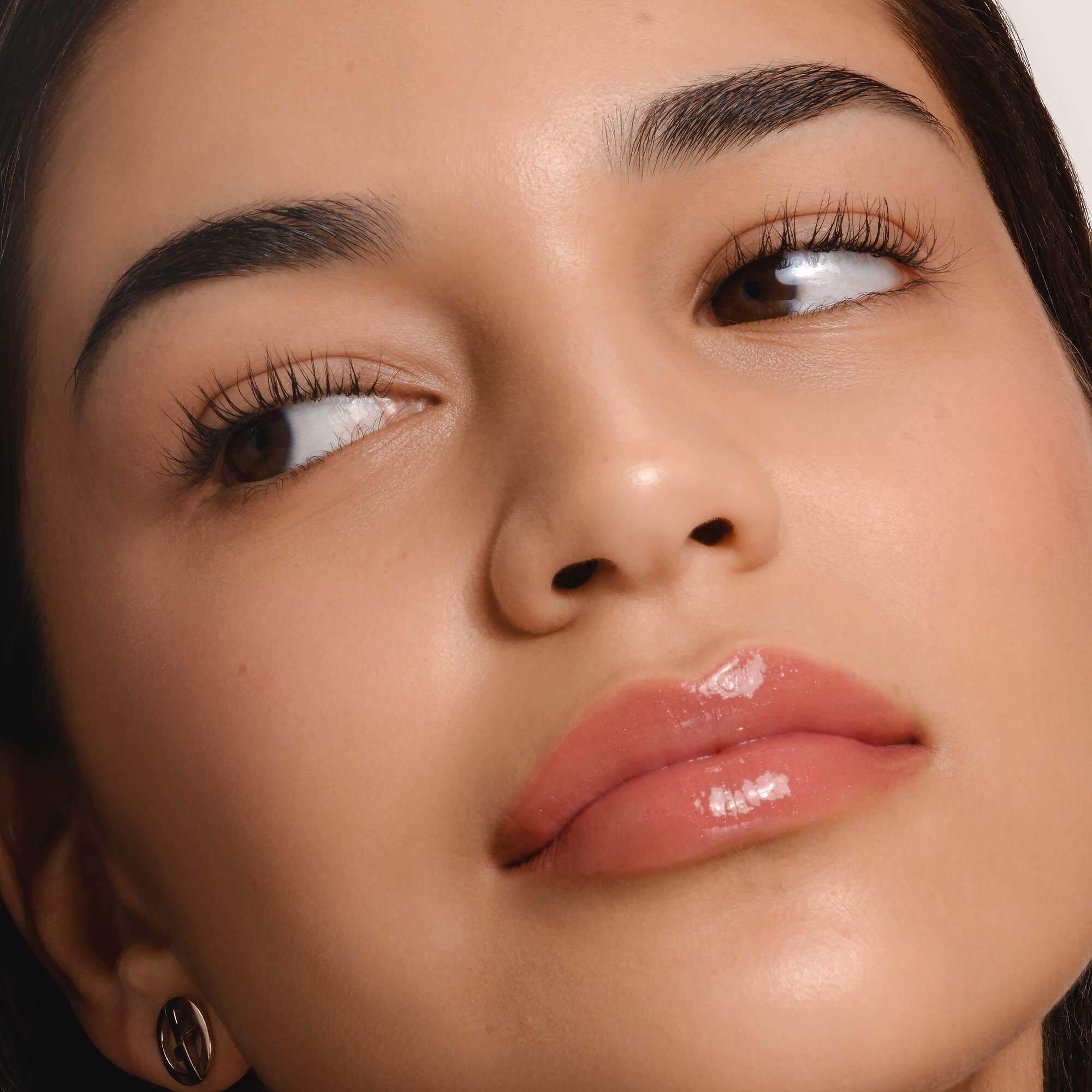 Armani Prisma Flash lippenstift aangebracht, met de nadruk op het strakke metallic ontwerp en de romige textuur van het product.