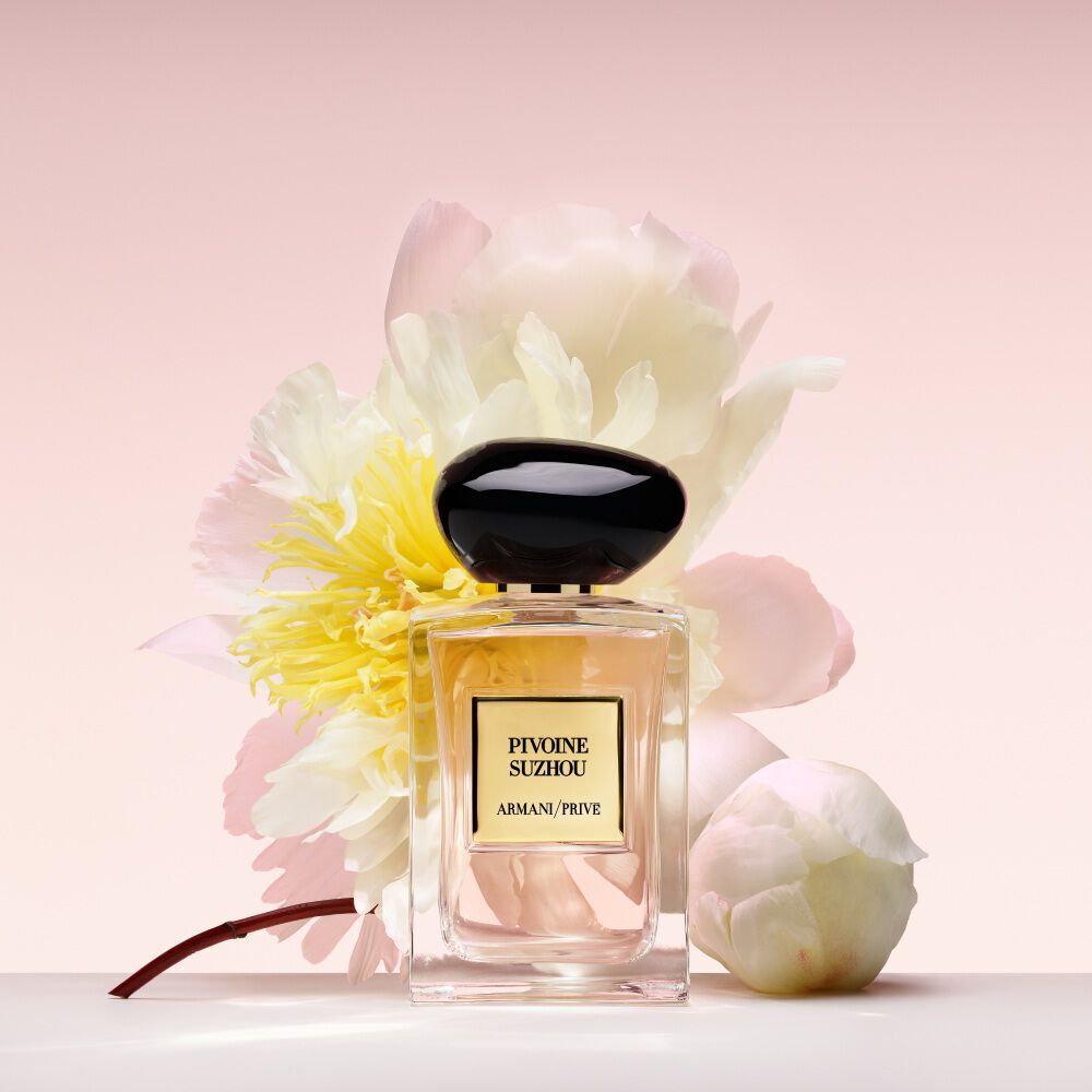 Armani/Prive Pivoine Suzhou: parfumfles tegen een bloeiende pioenroos, die het luxueuze bloemige karakter van de geur vangt.