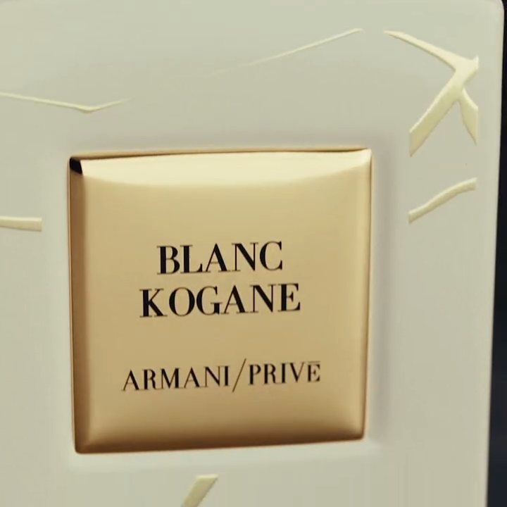 Een luxe parfumfles van Armani Prive met de naam 'Blanc Kogane' in stijlvolle gouden letters.