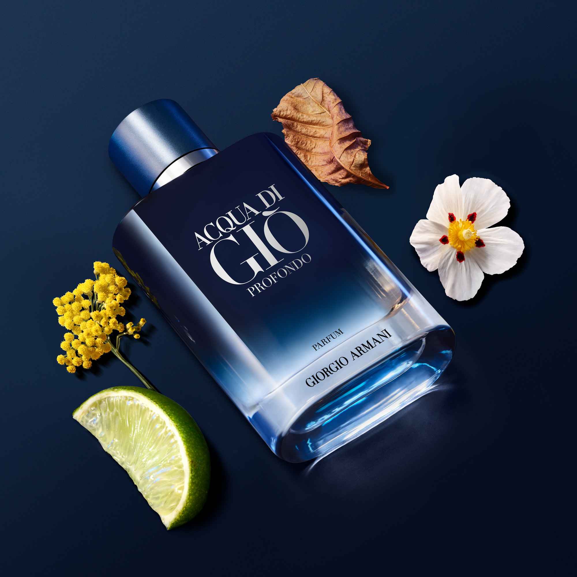 Flacon de parfum 'Acqua di Gio Profondo' de Giorgio Armani, entouré d'une lime, de fleurs et de feuilles sur fond bleu.